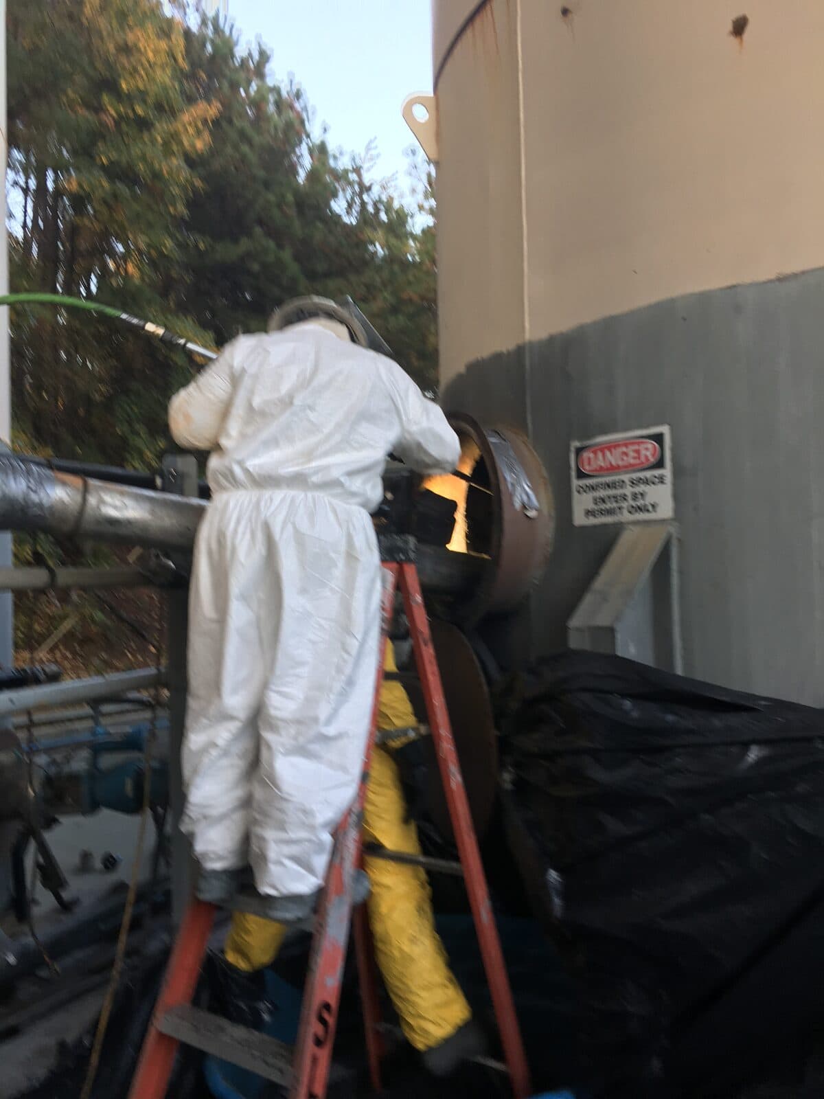 Cowart crew in Tyvek suits at a permit-required confined-space decontamination job