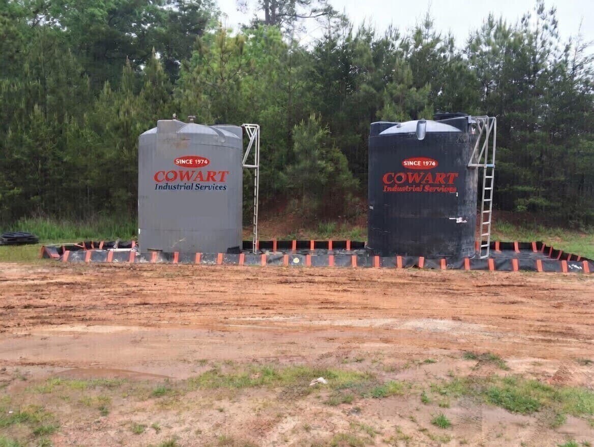 Cowart-branded bulk storage tanks inside a lined secondary-containment berm at an on-site treatment job