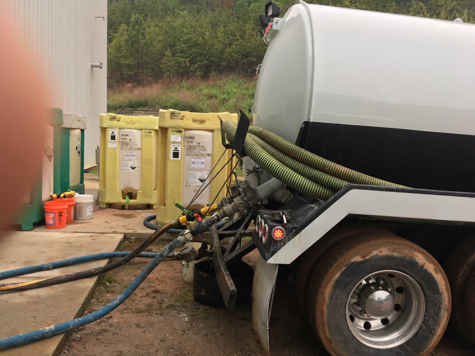 Cowart vacuum tanker connected by hoses for an on-site oil-water separator pump-out