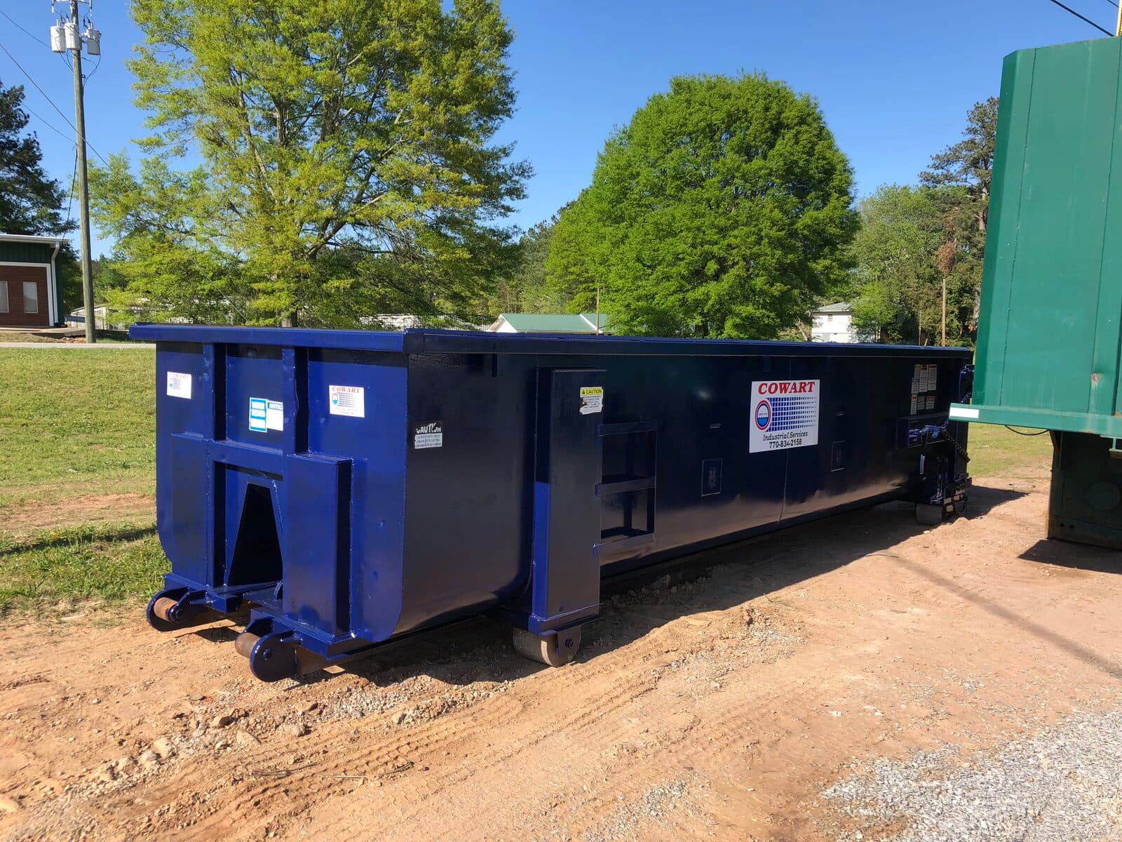 Cowart 20-yard roll-off box staged for solid waste disposal